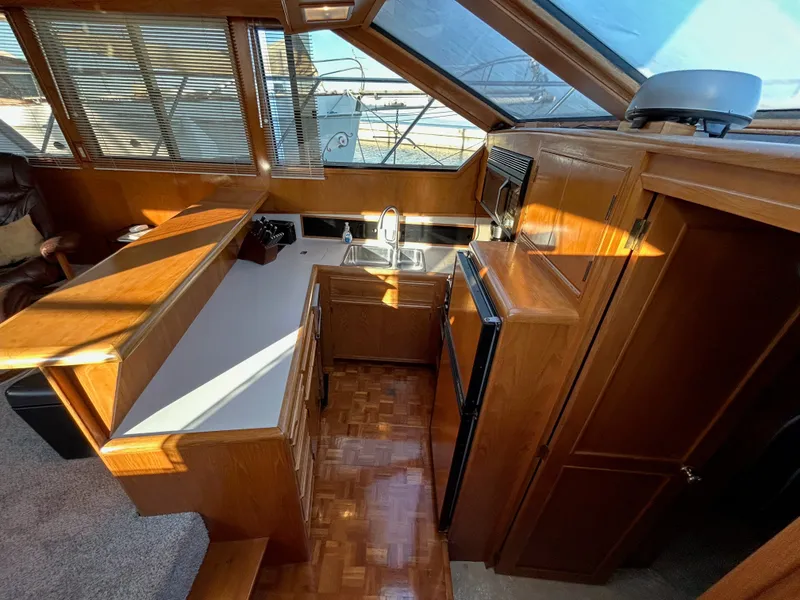 Slide: The Image of Interior of the 1988 Ocean Alexander 546 Cockpit Motoryacht with wood furnishings and kitchen. - 16