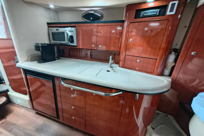 Slide: The Image of Luxurious 2006 Sea Ray 340 Sundancer yacht kitchen with wood cabinetry and modern appliances. - 19
