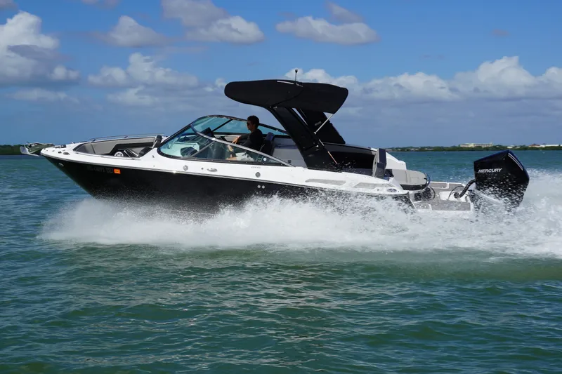 Slide: The Image of 2026 Monterey 255SS Super Sport boat cruising on open water under a clear blue sky. - 36