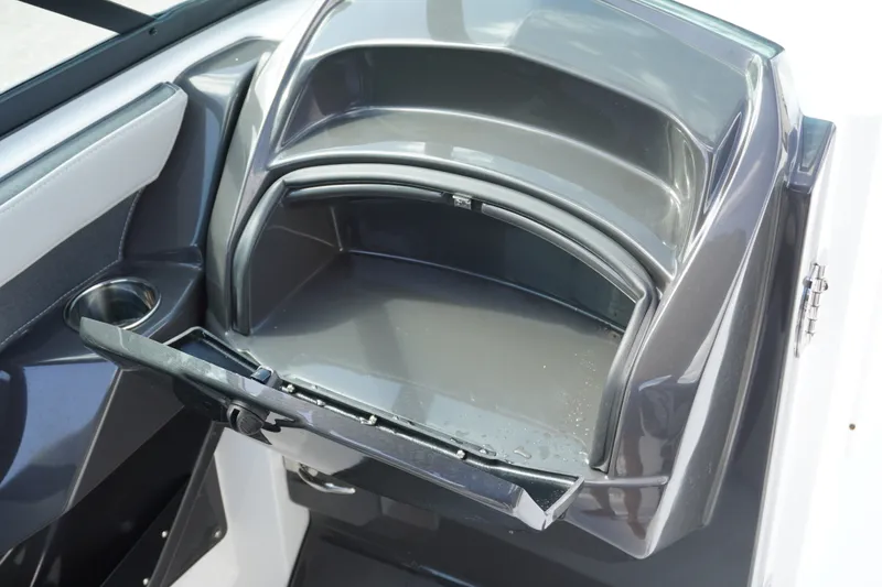Slide: The Image of Storage compartment in 2026 Monterey 255SS Super Sport boat, featuring sleek design and cup holder. - 28