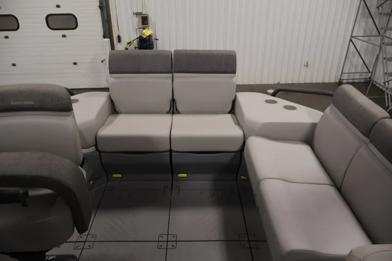 Slide: The Image of 2023 Sea-Doo Switch Sport Compact interior seating with gray upholstery in a garage setting. - 28