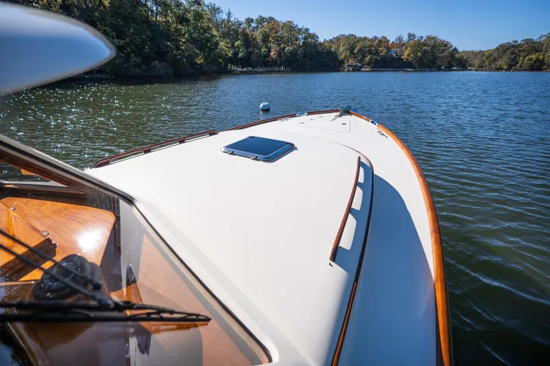 Slide: The Image of 2017 Hinckley Picnic Boat 37 MKIII cruising on a serene lake under clear skies. - 47
