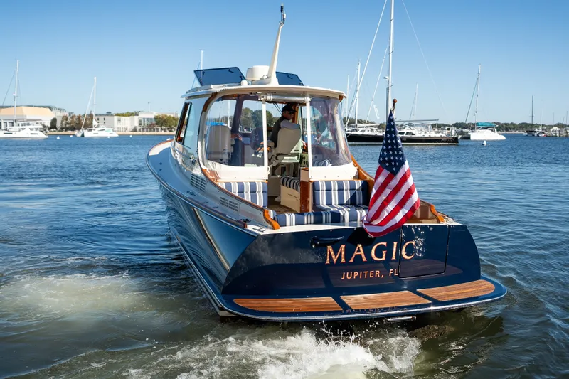 Slide: The Image of Hinckley Picnic Boat 37 MKIII, 2017 model, cruising in a marina with American flag. - 51