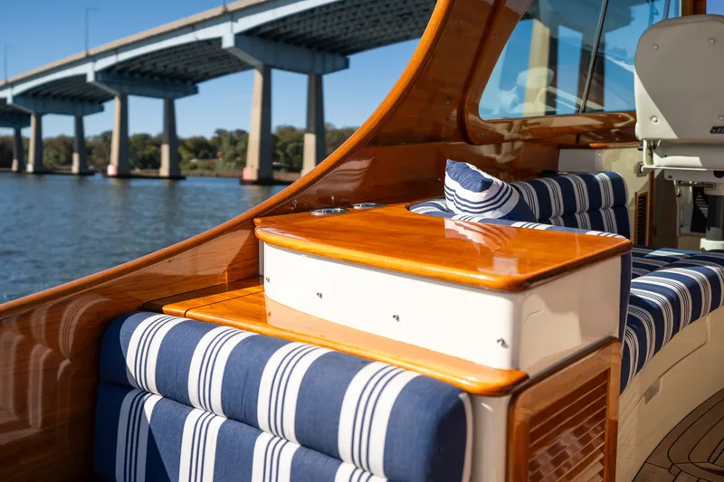 Slide: The Image of 2017 Hinckley Picnic Boat 37 MKIII interior with striped seating, wooden accents, and bridge view. - 16