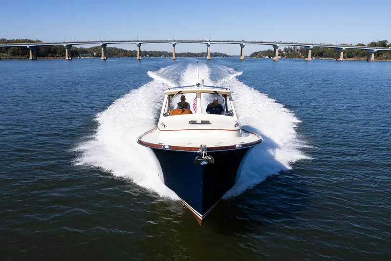 Slide: The Image of 2017 Hinckley Picnic Boat 37 MKIII cruising on a river with a bridge in the background. - 7