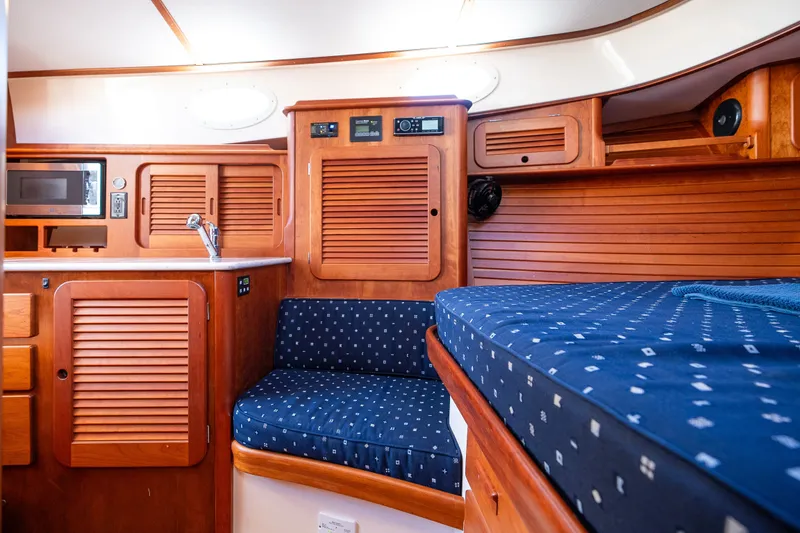 Slide: The Image of Interior of 2017 Hinckley Picnic Boat 37 MKIII with wood cabinetry and blue upholstery. - 38