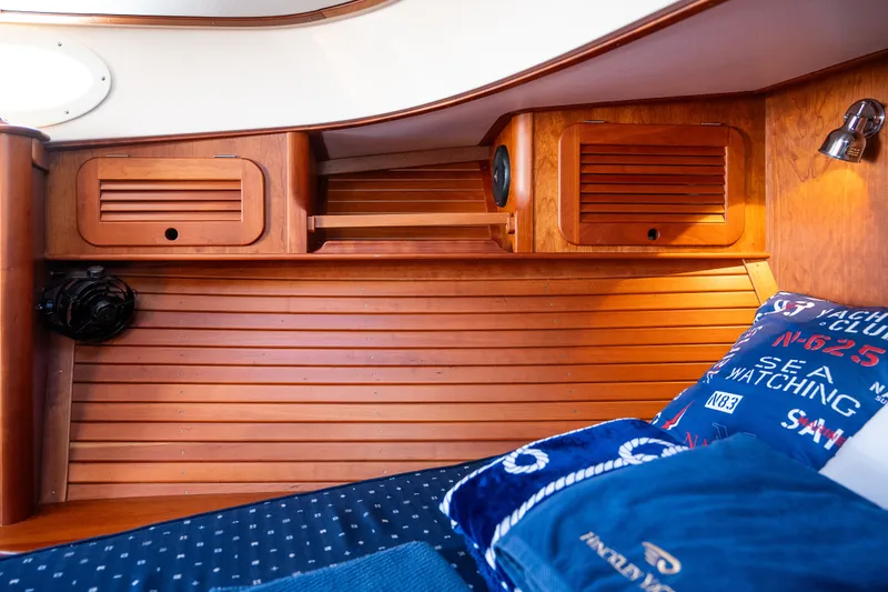 Slide: The Image of Hinckley Picnic Boat 37 MKIII 2017 cabin interior with wooden paneling and nautical-themed bedding. - 37