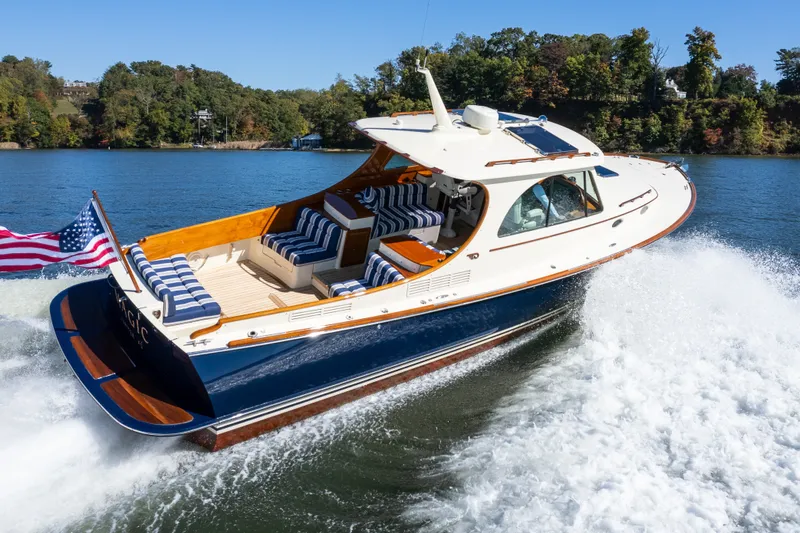 Slide: The Image of 2017 Hinckley Picnic Boat 37 MKIII cruising on a scenic lake with American flag. - 6