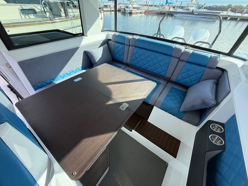 Slide: The Image of Interior of an Axopar 37 XC Cross Cabin with blue upholstery and a wooden table. - 26