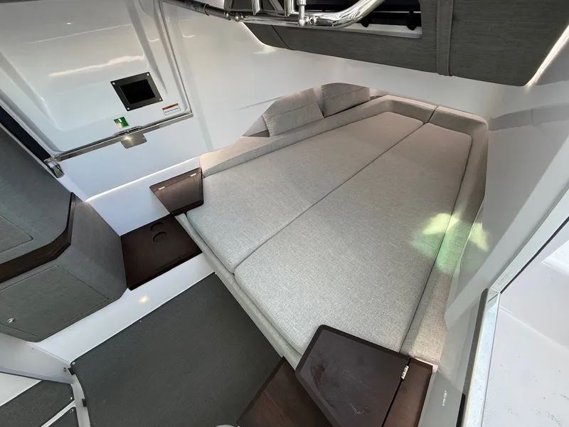 Slide: The Image of Interior of the 2024 Axopar 37 XC Cross Cabin with gray upholstered bed and wooden tables. - 20