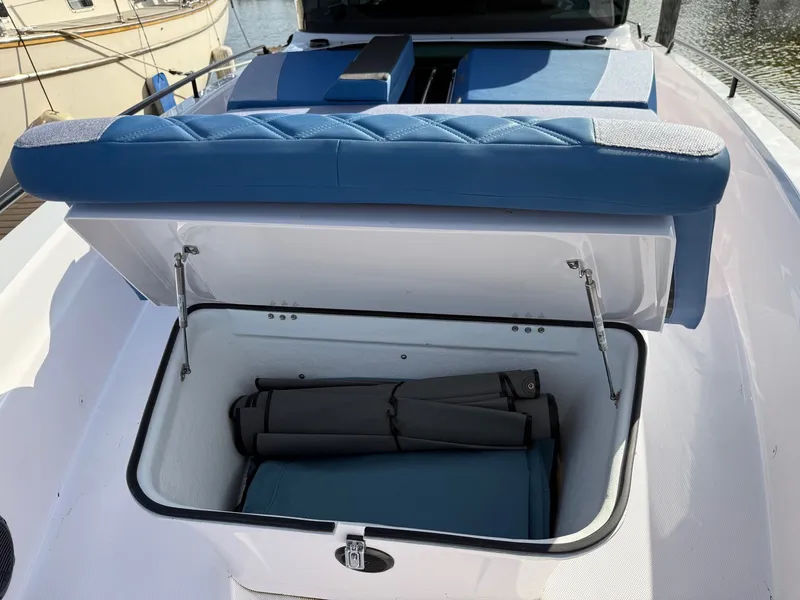 Slide: The Image of An open storage compartment on a boat with blue upholstery and a folded chair inside. - 17