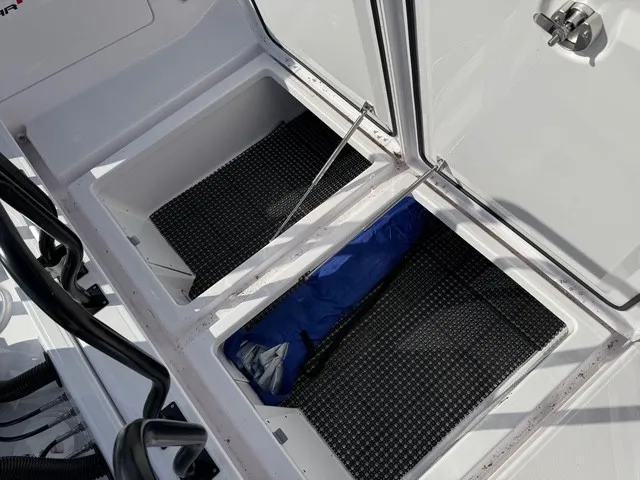 Slide: The Image of Two open storage compartments with black mats and a blue item in the right compartment. - 16