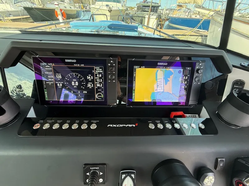 Slide: The Image of The dashboard of an Axopar 37 XC Cross Cabin with two Simrad displays and controls. - 28