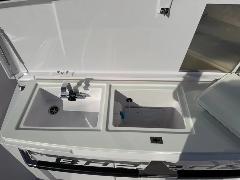 Slide: The Image of The 2024 Axopar 37 XC Cross Cabin features a compact sink and storage area. - 13
