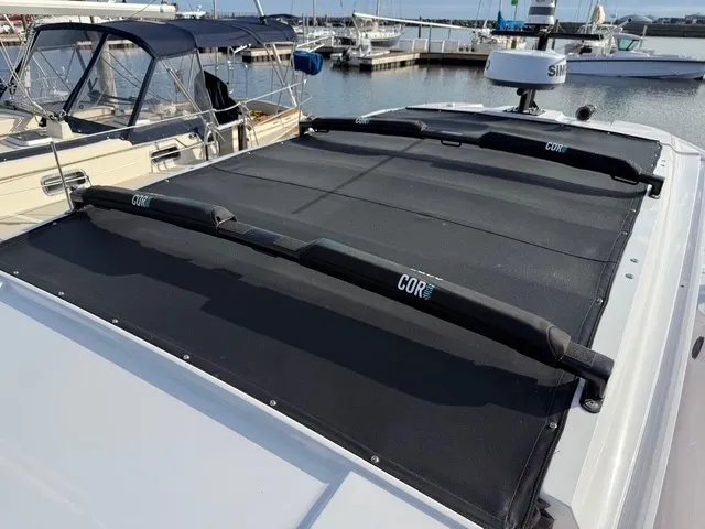 Slide: The Image of The image shows the roof of an Axopar 37 XC Cross Cabin with black covers at a marina. - 34