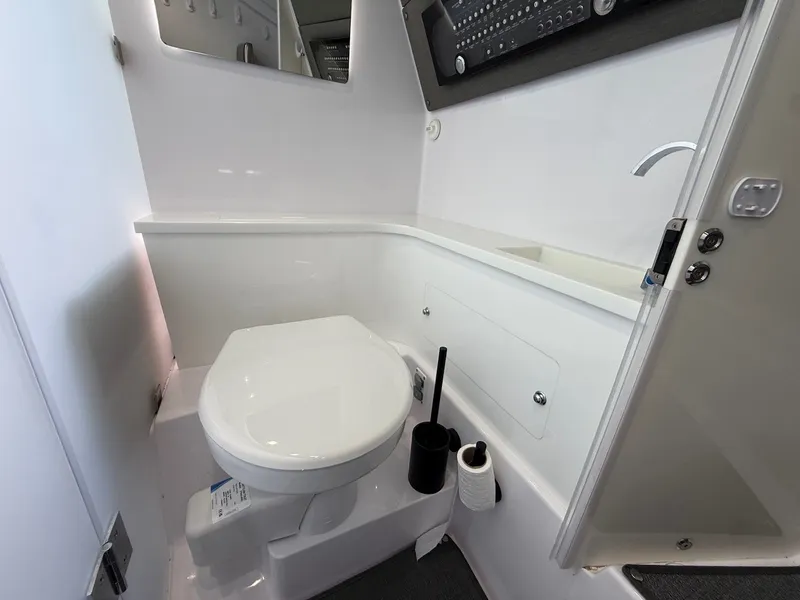 Slide: The Image of The image shows a modern boat toilet with white walls and a sink. - 23