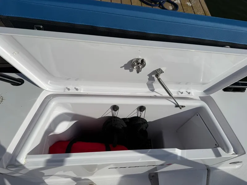 Slide: The Image of An open storage compartment on a boat with a red item and black ropes inside. - 15