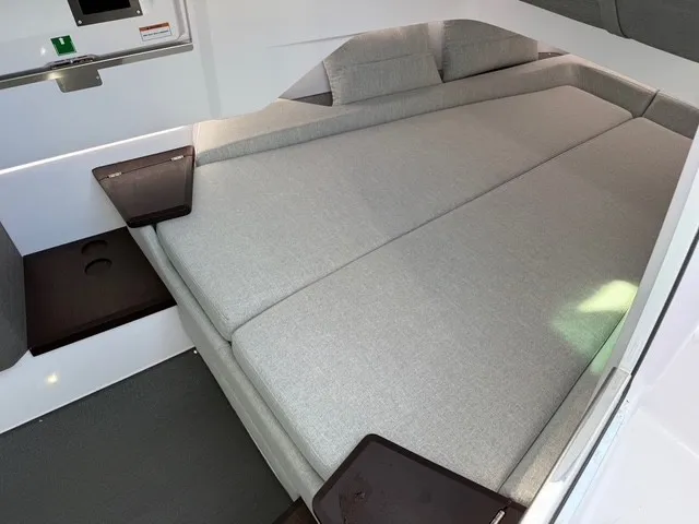 Slide: The Image of Interior of the 2024 Axopar 37 XC Cross Cabin featuring a large cushioned bed and wooden accents. - 19