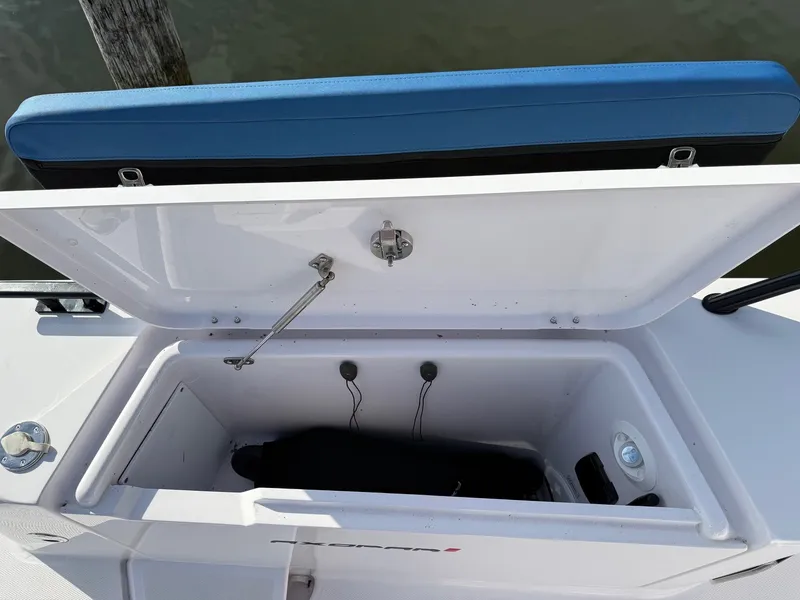 Slide: The Image of An open storage compartment on a boat with blue padding and a black item inside. - 14