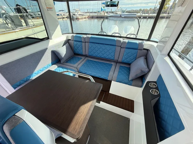 Slide: The Image of Interior of the 2024 Axopar 37 XC Cross Cabin with blue upholstery and a wooden table. - 25