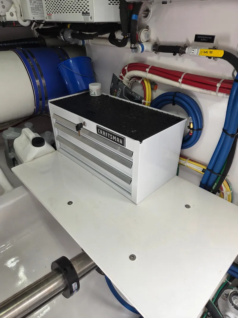 Slide: The Image of A toolbox on a shelf in a boat's engine room, surrounded by pipes and cables. - 30