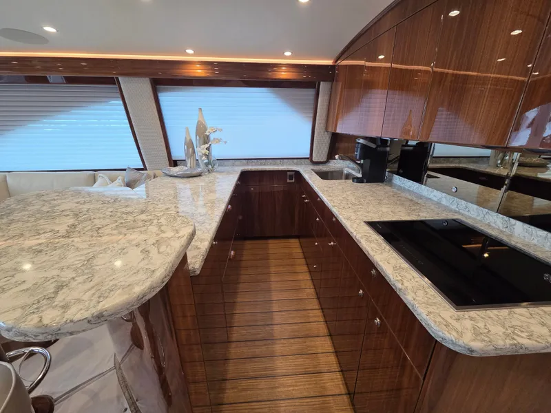 Slide: The Image of The kitchen of a modern yacht with marble countertops and glossy wooden cabinets. - 18