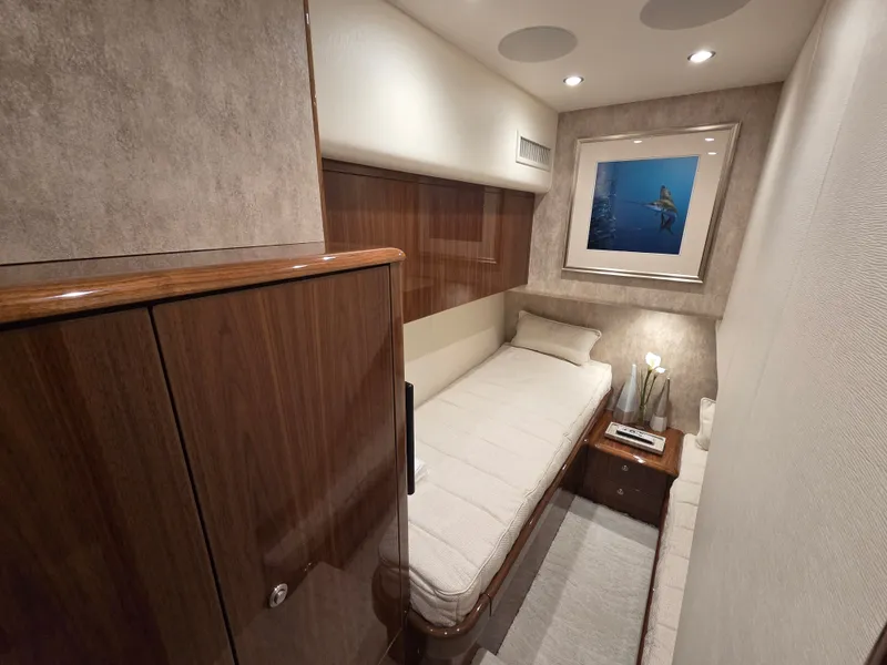 Slide: The Image of Interior of a 2023 Viking Convertible with a single bed, wooden furniture, and a framed picture. - 25