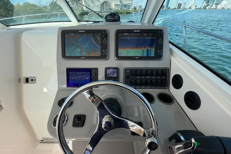 Slide: The Image of Helm of 2014 Boston Whaler 315 Conquest with navigation screens and steering wheel. - 31