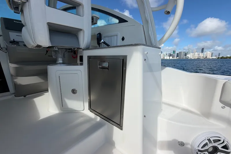 Slide: The Image of 2014 Boston Whaler 315 Conquest interior with city skyline view, featuring seating and storage. - 18