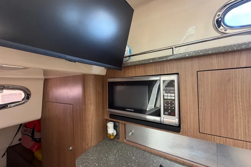 Slide: The Image of 2014 Boston Whaler 315 Conquest interior with microwave and TV in cabin. - 55