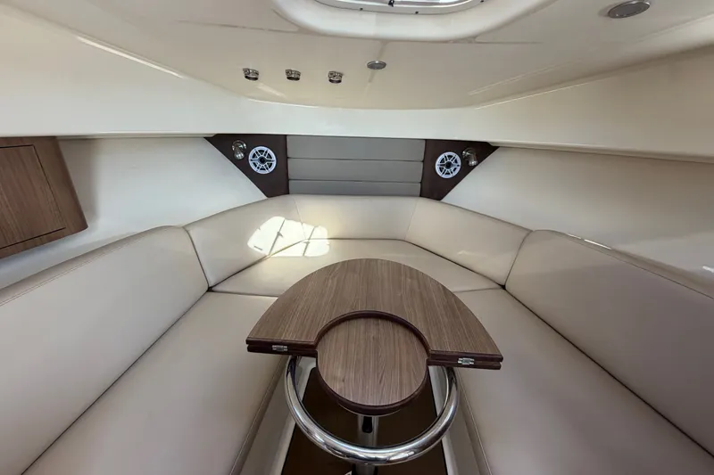 Slide: The Image of Interior of 2014 Boston Whaler 315 Conquest with beige seating and wooden table. - 47