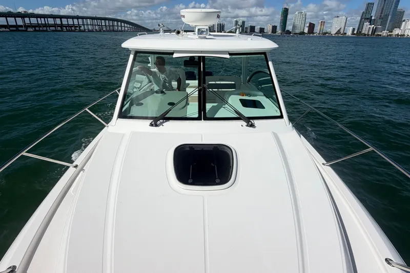 Slide: The Image of 2014 Boston Whaler 315 Conquest cruising near city skyline and bridge. - 59