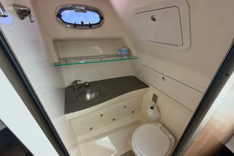 Slide: The Image of Compact bathroom in 2014 Boston Whaler 315 Conquest boat with sink and toilet. - 50