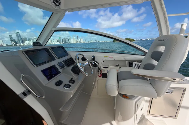 Slide: The Image of 2014 Boston Whaler 315 Conquest helm with city skyline view, featuring modern navigation equipment. - 27