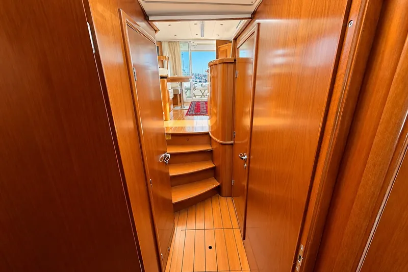 Slide: The Image of Interior view of 2005 Beneteau Swift Trawler 42, featuring polished wood paneling and stairs. - 21