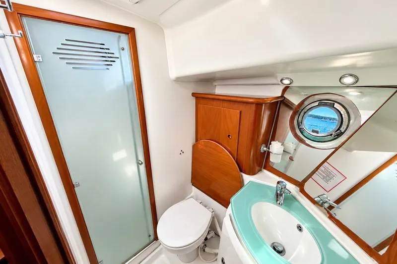 Slide: The Image of 2005 Beneteau Swift Trawler 42 bathroom with shower, sink, and porthole window. - 19