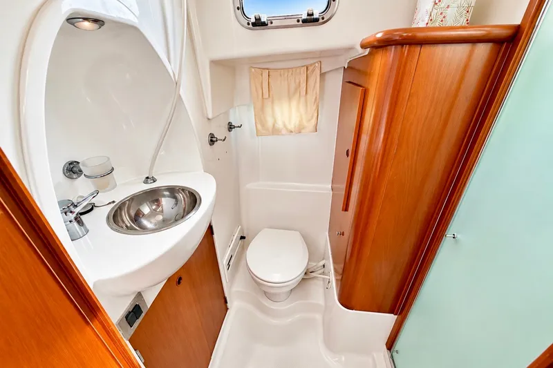 Slide: The Image of Bathroom interior of 2005 Beneteau Swift Trawler 42 with sink, toilet, and wooden cabinetry. - 20