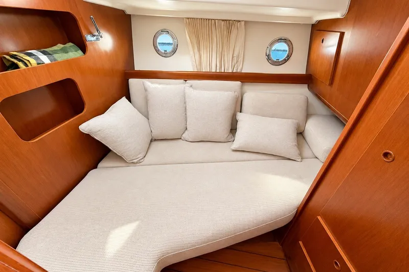 Slide: The Image of Cozy cabin interior of 2005 Beneteau Swift Trawler 42 with plush cushions and wooden finish. - 18