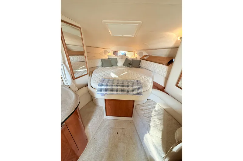 Slide: The Image of Interior of 2001 Sea Ray 340 Sundancer, featuring a cozy, well-lit cabin with a comfortable bed. - 16