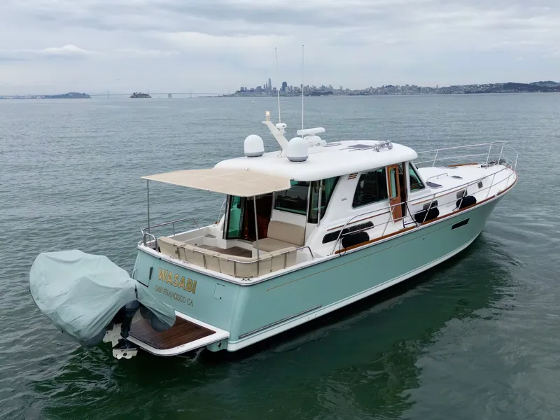 Slide: The Image of 2016 Sabre 48 Salon Express on calm water with city skyline in the background. - 4