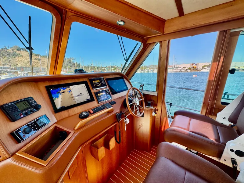 Slide: The Image of Interior view of a 2016 Sabre 48 Salon Express helm with wood finish and modern instruments. - 30