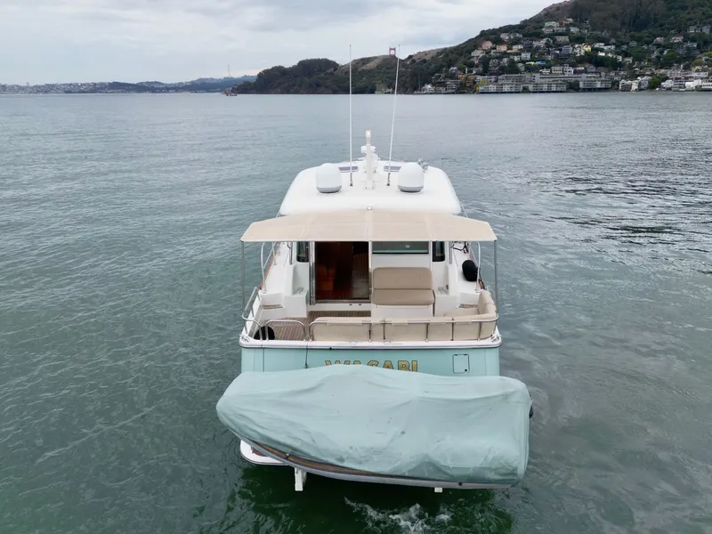 Slide: The Image of Rear view of a 2016 Sabre 48 Salon Express on calm water with a covered dinghy. - 3