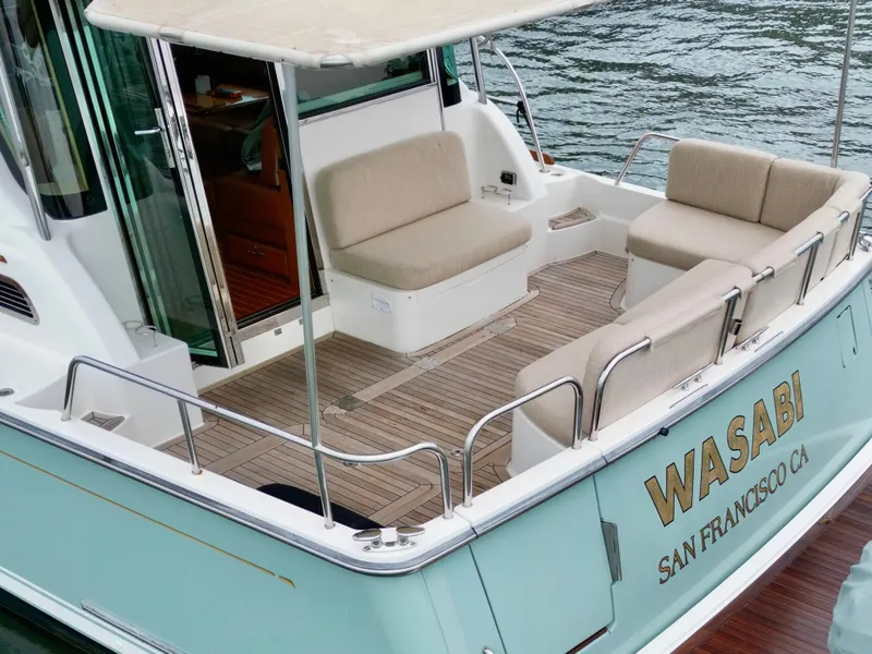Slide: The Image of The image shows the stern of a 2016 Sabre 48 Salon Express with seating area and teak flooring. - 9