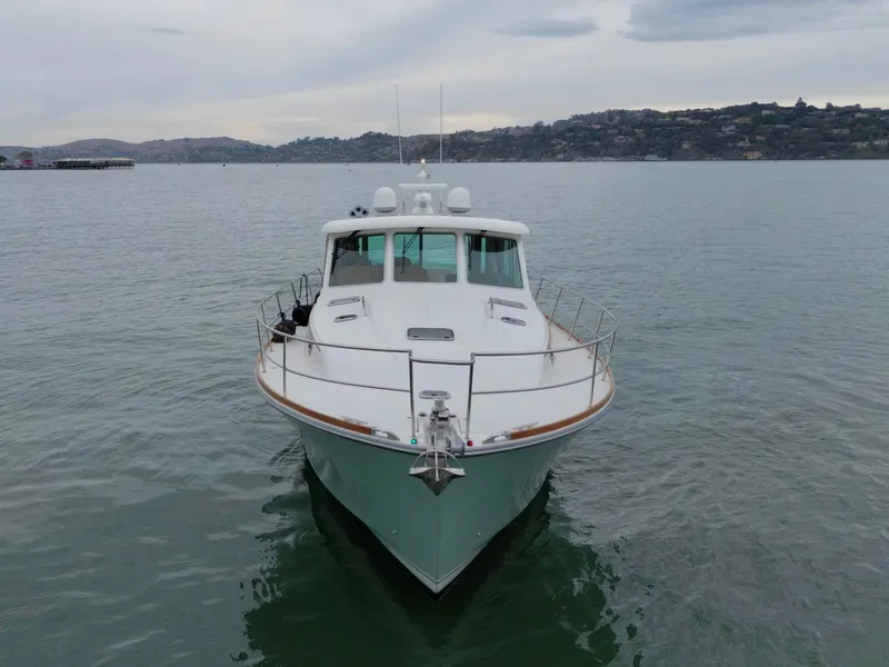Slide: The Image of The 2016 Sabre 48 Salon Express cruises on calm waters with a scenic coastal backdrop. - 7