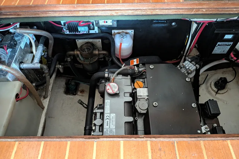 Slide: The Image of Engine compartment of a 1995 Nordic Tug 26, showcasing mechanical components and wiring. - 38