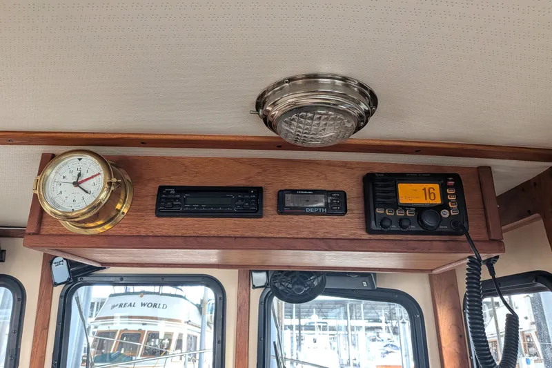 Slide: The Image of Interior of a 1995 Nordic Tug 26 with clock, radio, and depth gauge. - 24