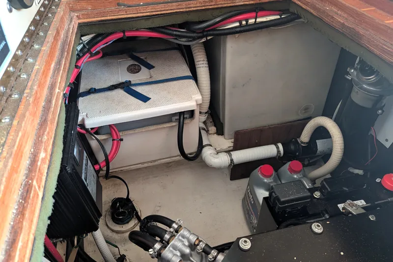 Slide: The Image of Engine compartment of a 1995 Nordic Tug 26, featuring wiring and fluid containers. - 36