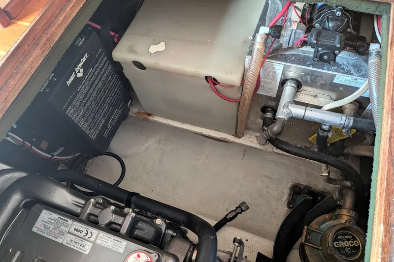 Slide: The Image of Engine compartment of a 1995 Nordic Tug 26, showcasing mechanical components and wiring. - 35