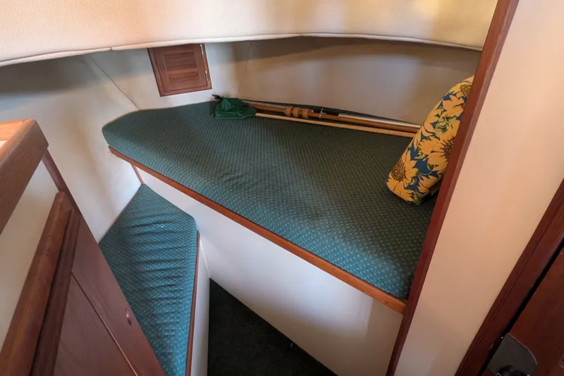 Slide: The Image of Cozy cabin interior of 1995 Nordic Tug 26 with green cushioned berth and floral pillow. - 31