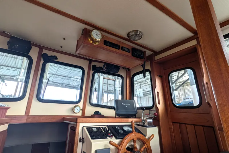 Slide: The Image of Interior of a 1995 Nordic Tug 26 boat with wooden helm and navigation equipment. - 23